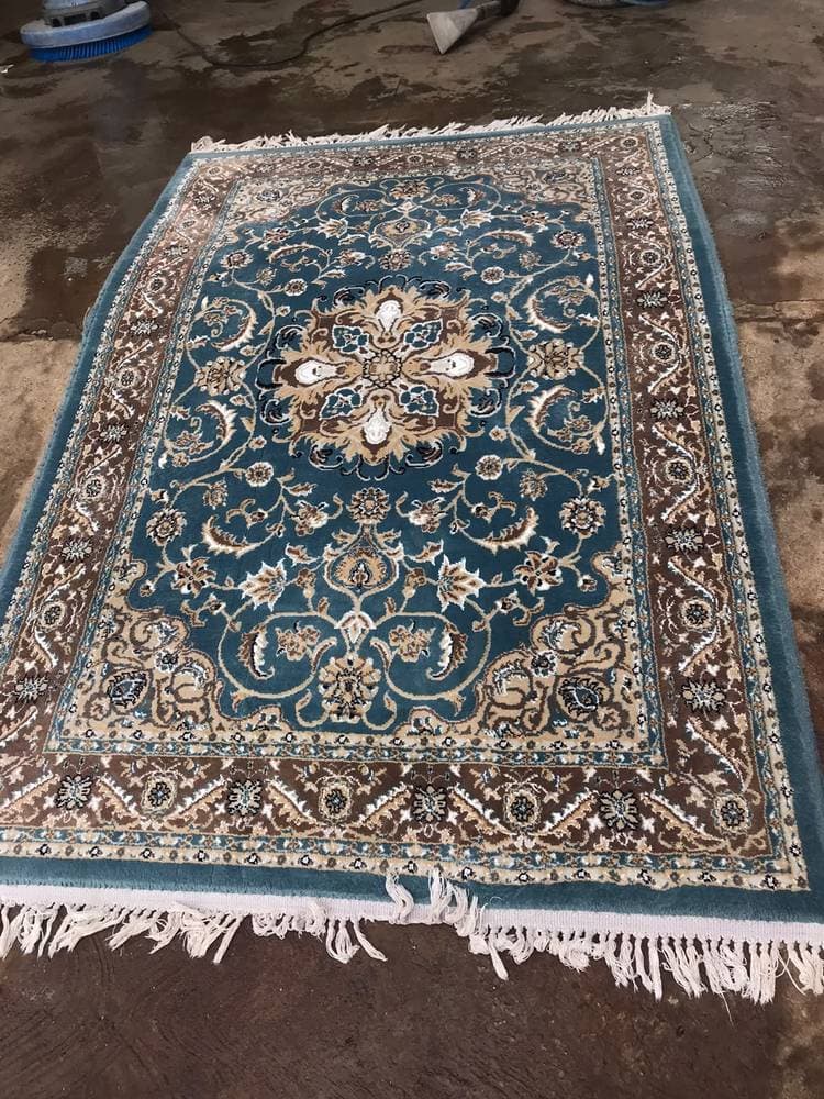 An area rug freshly cleaned on Guardian's workshop floor, with extraction equipment behind it.